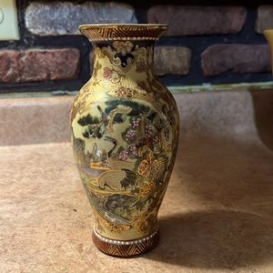 Es un florero.  Chino. Muy bonito con acabados en  pintura de. Color oro